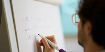 Person writing on a board